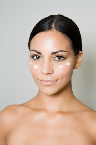 Young woman with moisturizer on face